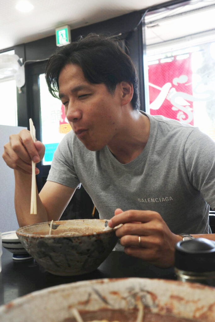 スープを味わい、静かに満たされる笹田さんの表情。八龍での“これしか頼まない”時間のひとコマ。