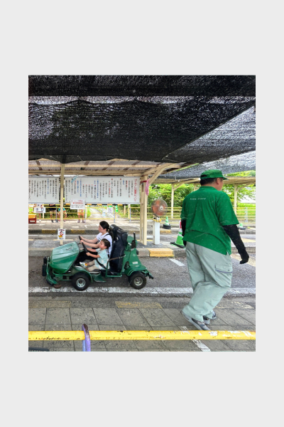 大高緑地・交通公園のゴーカート乗り場で並ぶ親子とスタッフ。日除けの下、変わらない順番待ちの風景が今もそのまま。