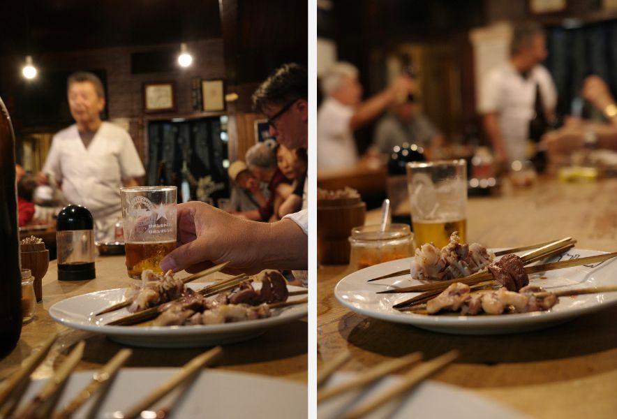 「なかの」で常連客がビールを手に焼き鳥を味わう様子。店の日常を切り取ったカウンター風景。