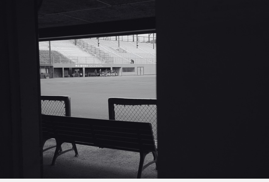 ベンチ裏から望む名古屋・熱田球場のグラウンドと少年野球チーム