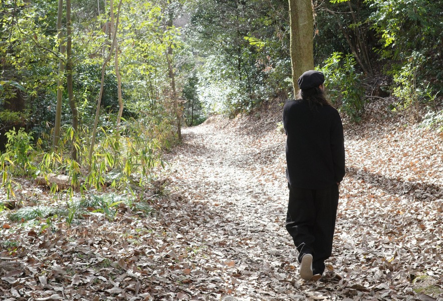 木々に囲まれた場所で佇むRas Taroのポートレート