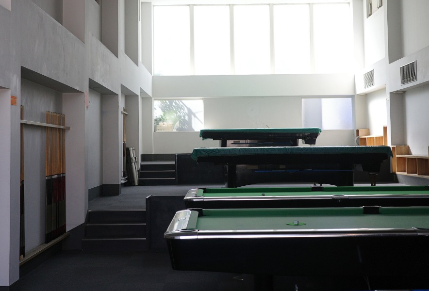 名古屋市昭和区・曙通りのビリヤード場「友楽」。高い窓から柔らかい光が差し込む、段差のある静かな空間。