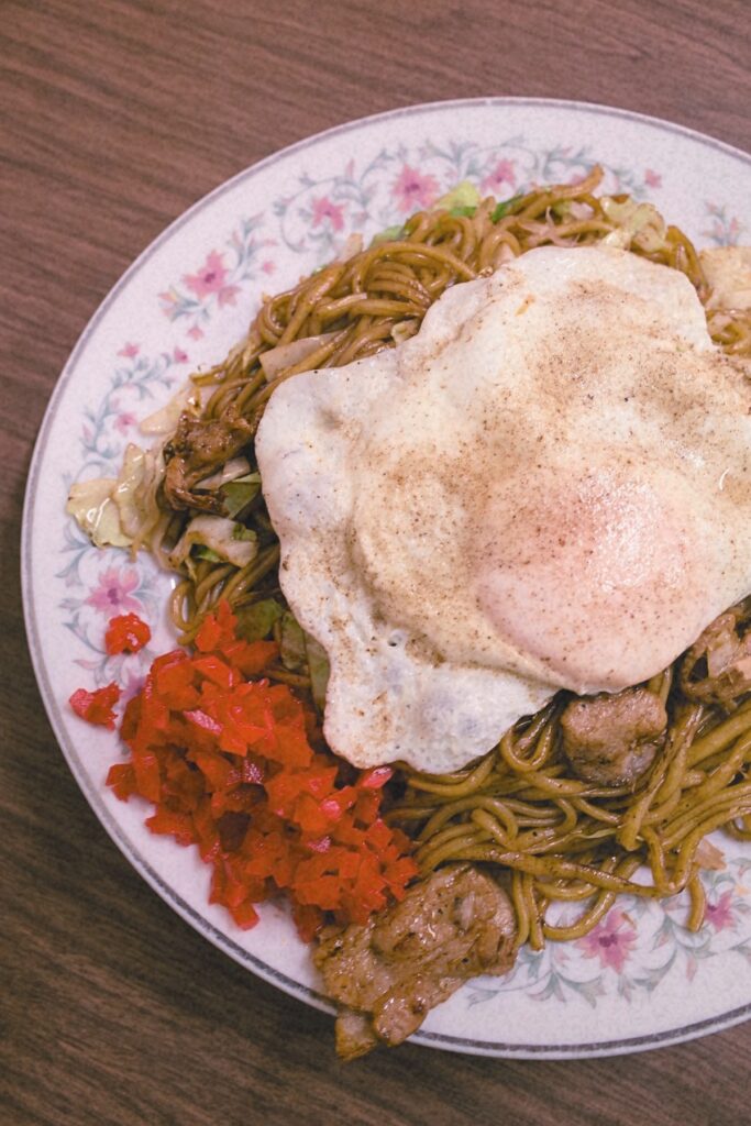 目玉焼きと紅しょうがを添えた板鼻氷店の特盛肉焼きそば。15年以上通った岡ちゃんが「板鼻以外愛せない」と語った一皿。