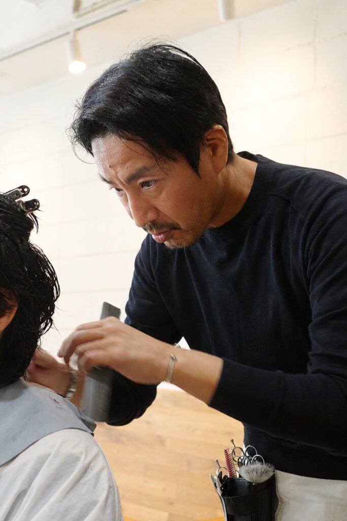 KOKOKARA Hairでお客様の髪を整える阿部浩貴さん。