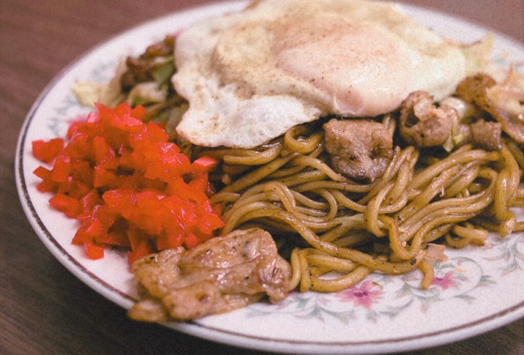 目玉焼きと紅しょうがを添えた板鼻氷店の特盛肉焼きそば。15年以上通った常連・岡ちゃんが愛した一皿。