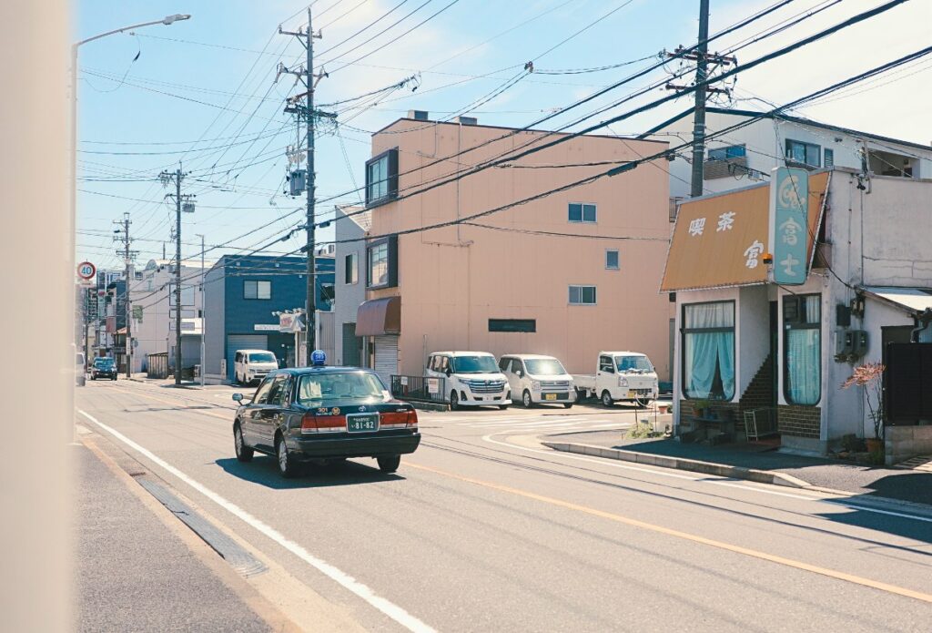 喫茶富士へ向かう道。八熊通から少し西へ進むと、住宅街の中にぽつんと店が現れる。通りを行き交う車と電線の風景も、この街の日常の一部。