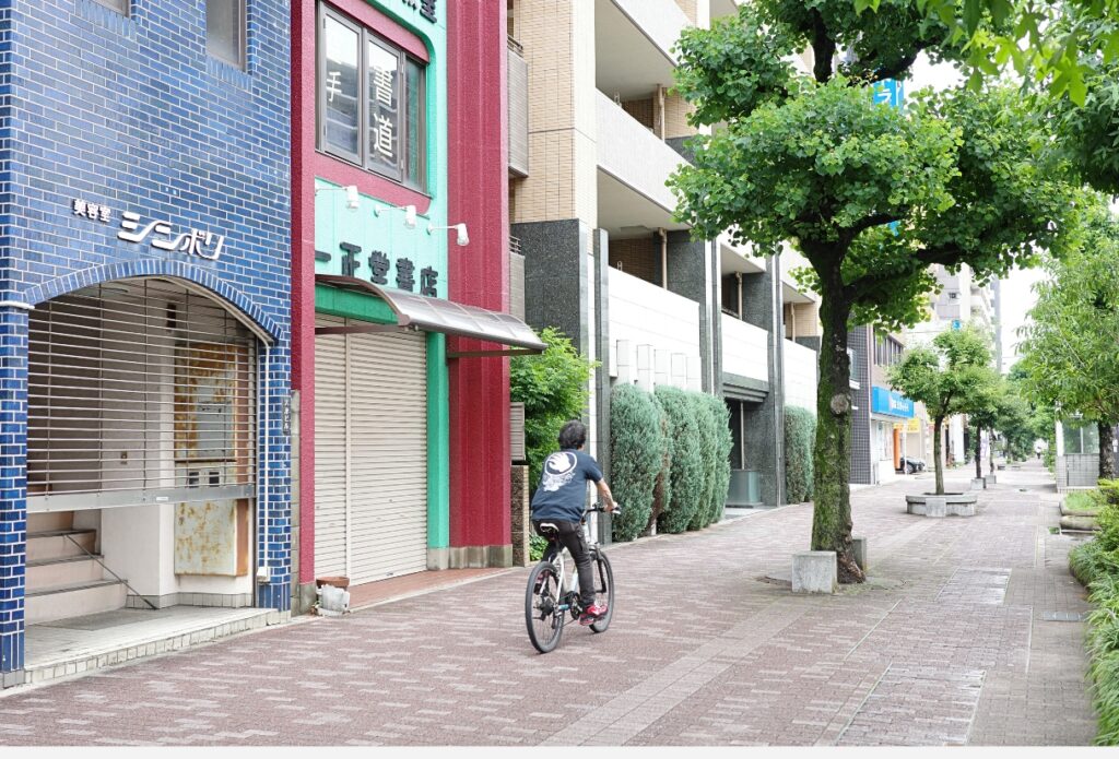 一正堂書店の外観と、店の前を自転車で通り過ぎる人