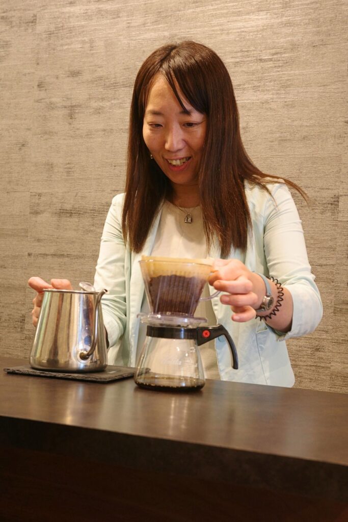 名古屋・昭和区「Grains de café」店主の三冨由杏子さん。カウンターでハンドドリップコーヒーを淹れる様子。