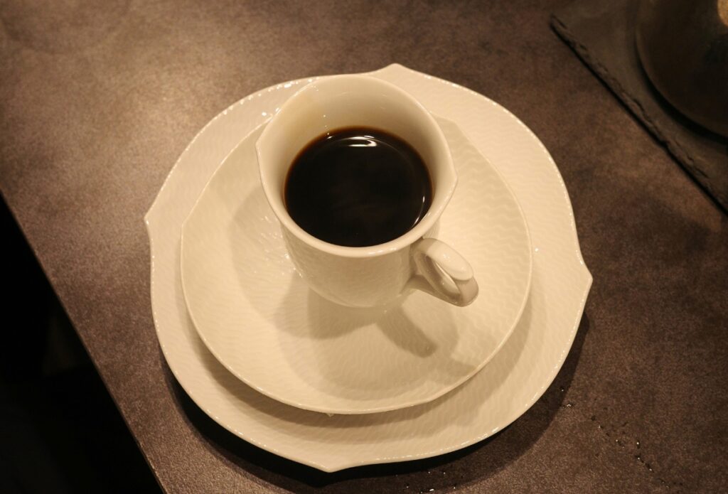 名古屋・昭和区「Grains de café」で提供されるハンドドリップコーヒー。白いカップと皿に注がれたブラック