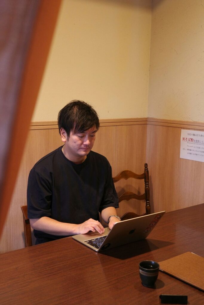 山本屋大久手店の店内で、ノートパソコンに向かう5代目・青木裕典さん