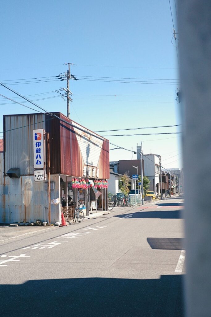 名古屋市北区・金城市場の外観。伊藤ハムの古い看板とイースターズナゴヤの看板が残る、トタン屋根の市場