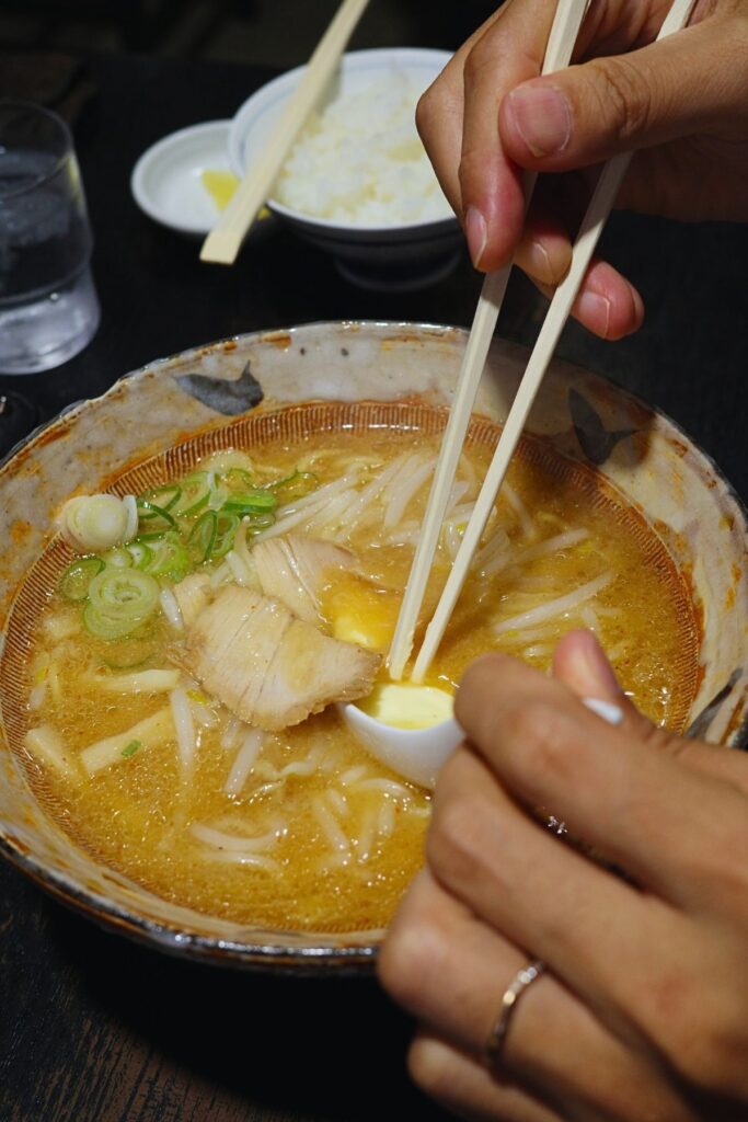 バターが溶けていく八龍の味噌バターラーメン。チャーシューともやし、奥にライス