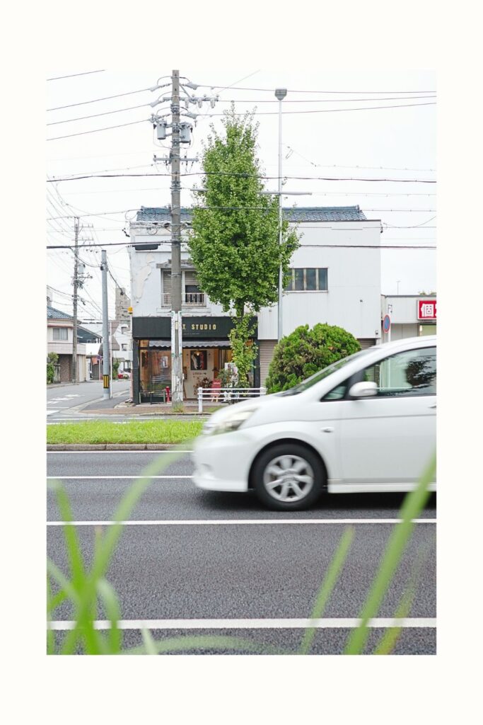 名古屋市南区のギャラリー「ART STUDIO」。古い建物を利用した店舗の前を自転車で通り過ぎる人。
コピー