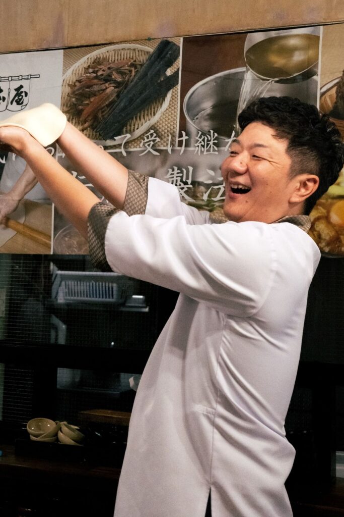 うどん生地を手に笑顔を見せる山本屋大久手店5代目・青木晃佑さん