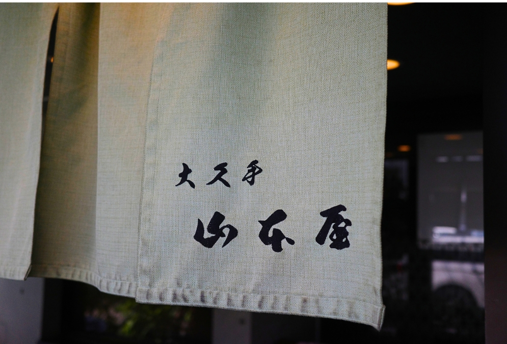 大久手 山本屋の暖簾。淡い緑の生地に墨文字の屋号